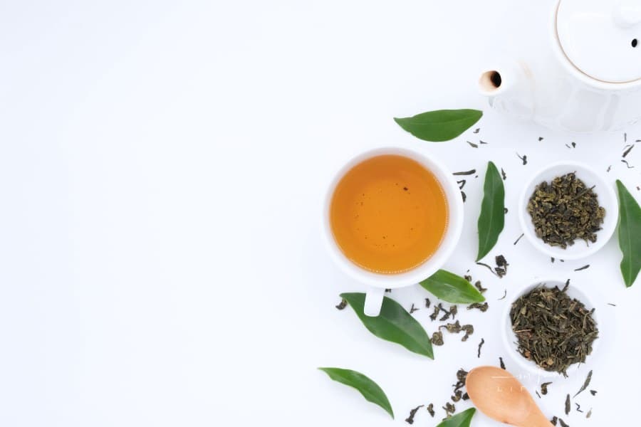 Green tea with leaves on white background