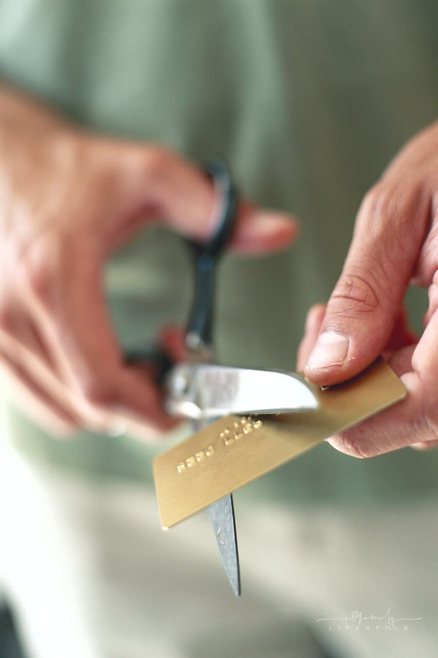 woman's hands cutting a credit card with scissors