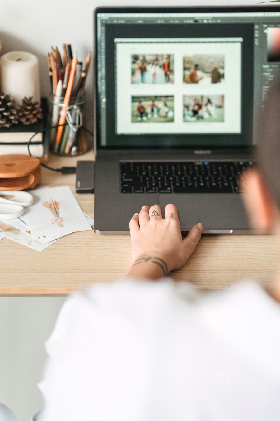 Crop faceless person editing photos on laptop