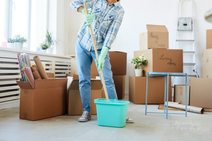 Young Woman Mopping Floors around moving boxes