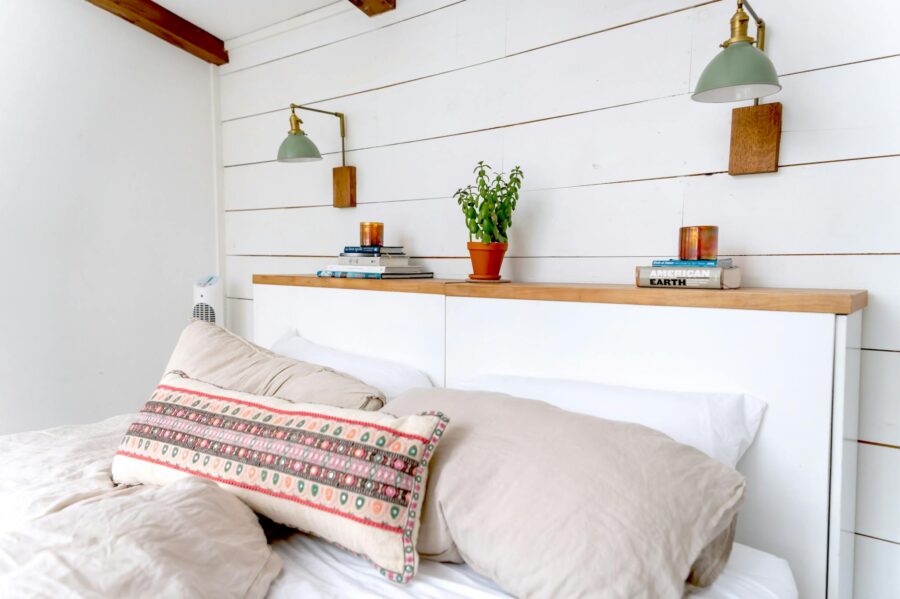 Minimalist bedroom with white wood paneling, plants, and cozy textiles. Ideal for interior design inspiration.