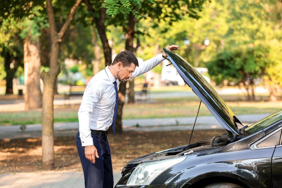 Stressed Businessman near broken-down, damaged Car Outdoors