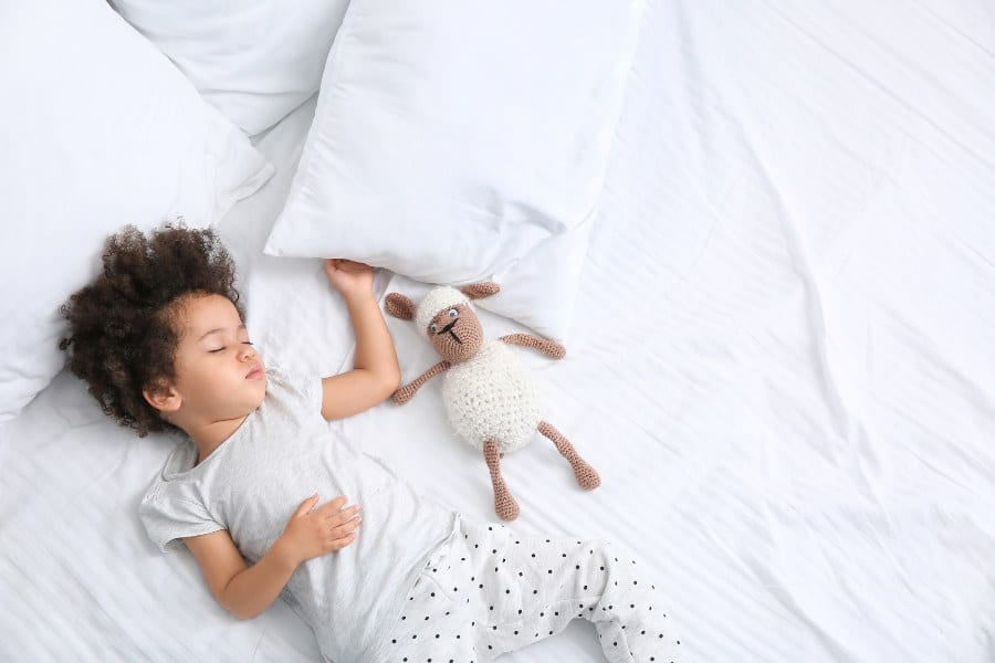 Little Girl with Stuffed Toy Sleeping in Bed