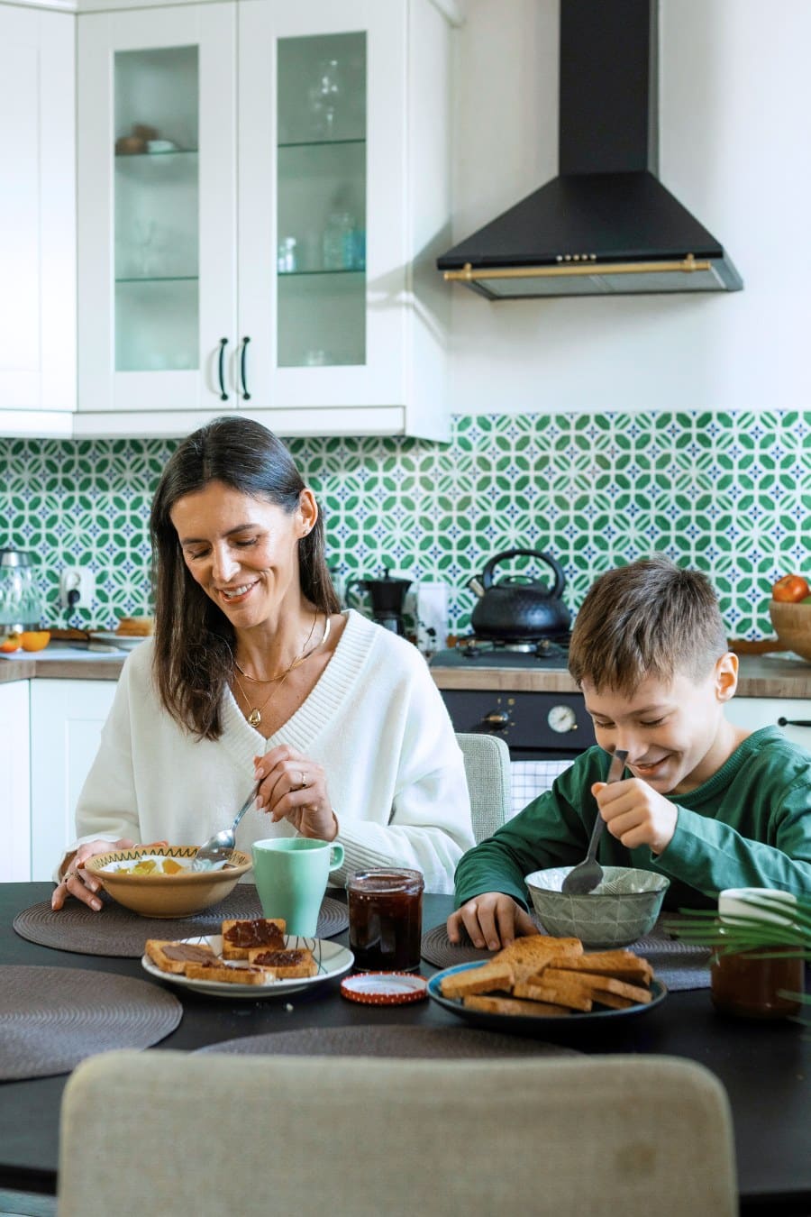 Mother and son eating breakfast in the kitchen