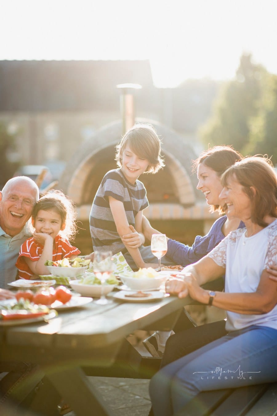 UK Family sitting outside eating together