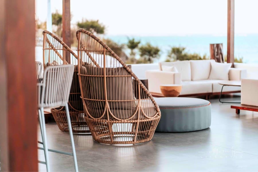 brown wicker egg chairs on patio with sofa in foreground
