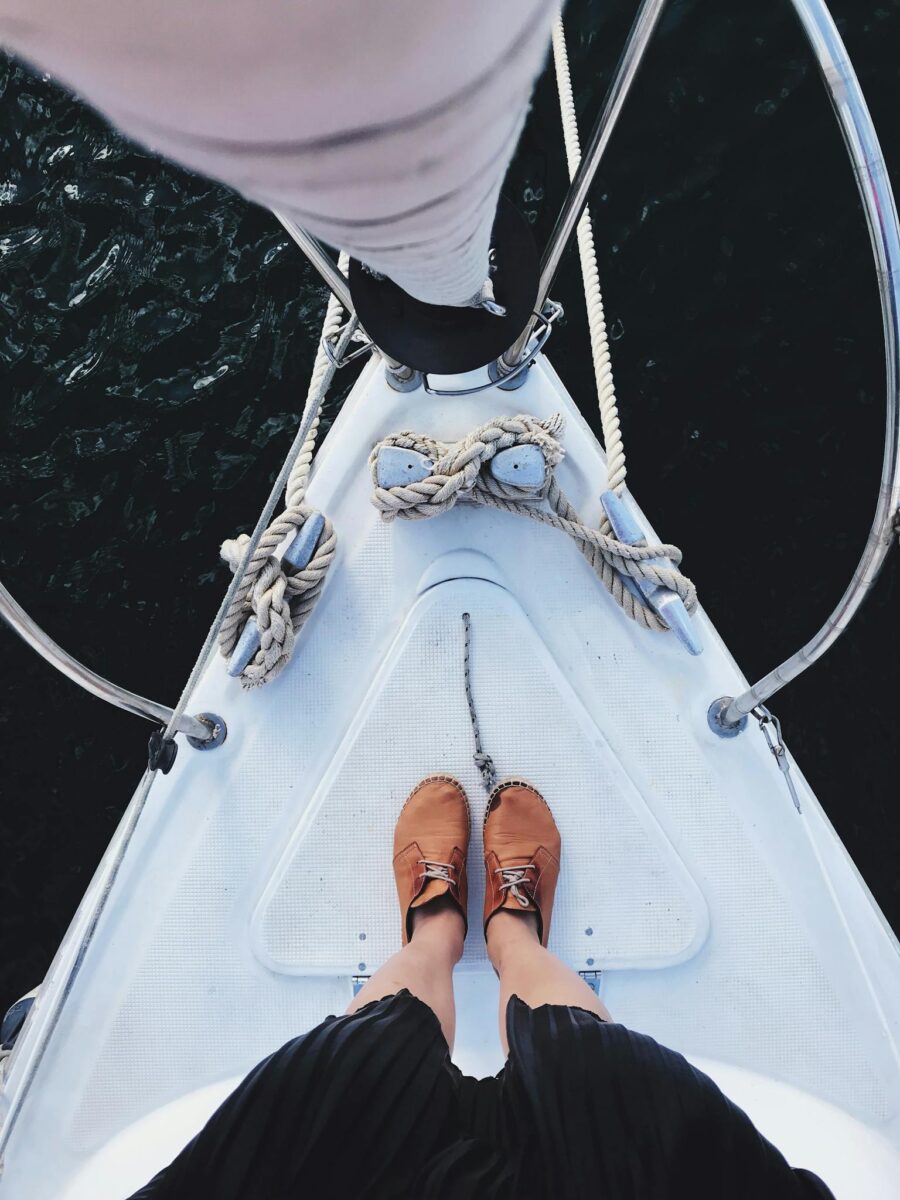 Person on a sailboat with moccasins and visible nautical ropes.