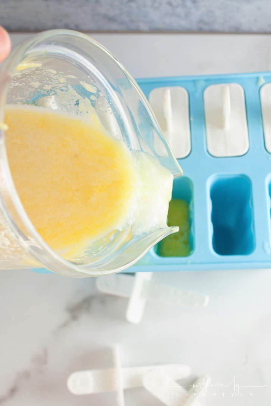 Pina Colada ice pops pouring mixture into molds
