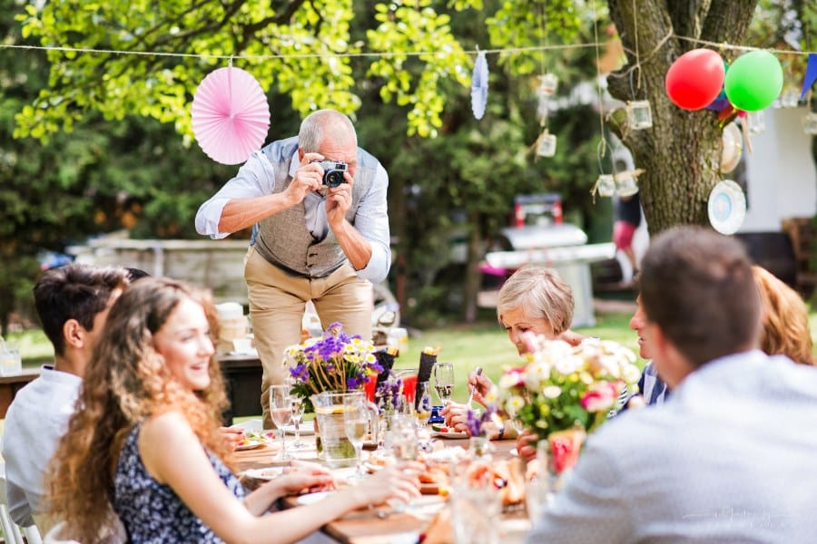 family celebration outside, garden party, grandfather taking a picture