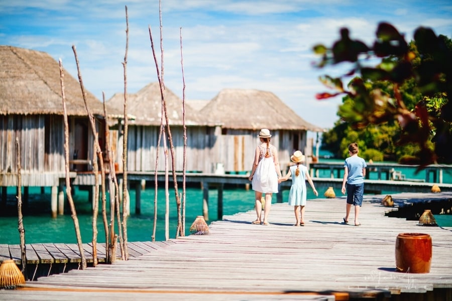 How To Plan An International Vacation With Your Family- A group of people walking on a dock by a body of water