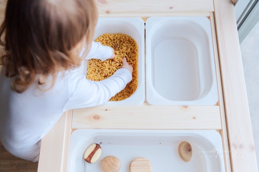 Small Child Playing With Macaroni Pasta; sensory play
