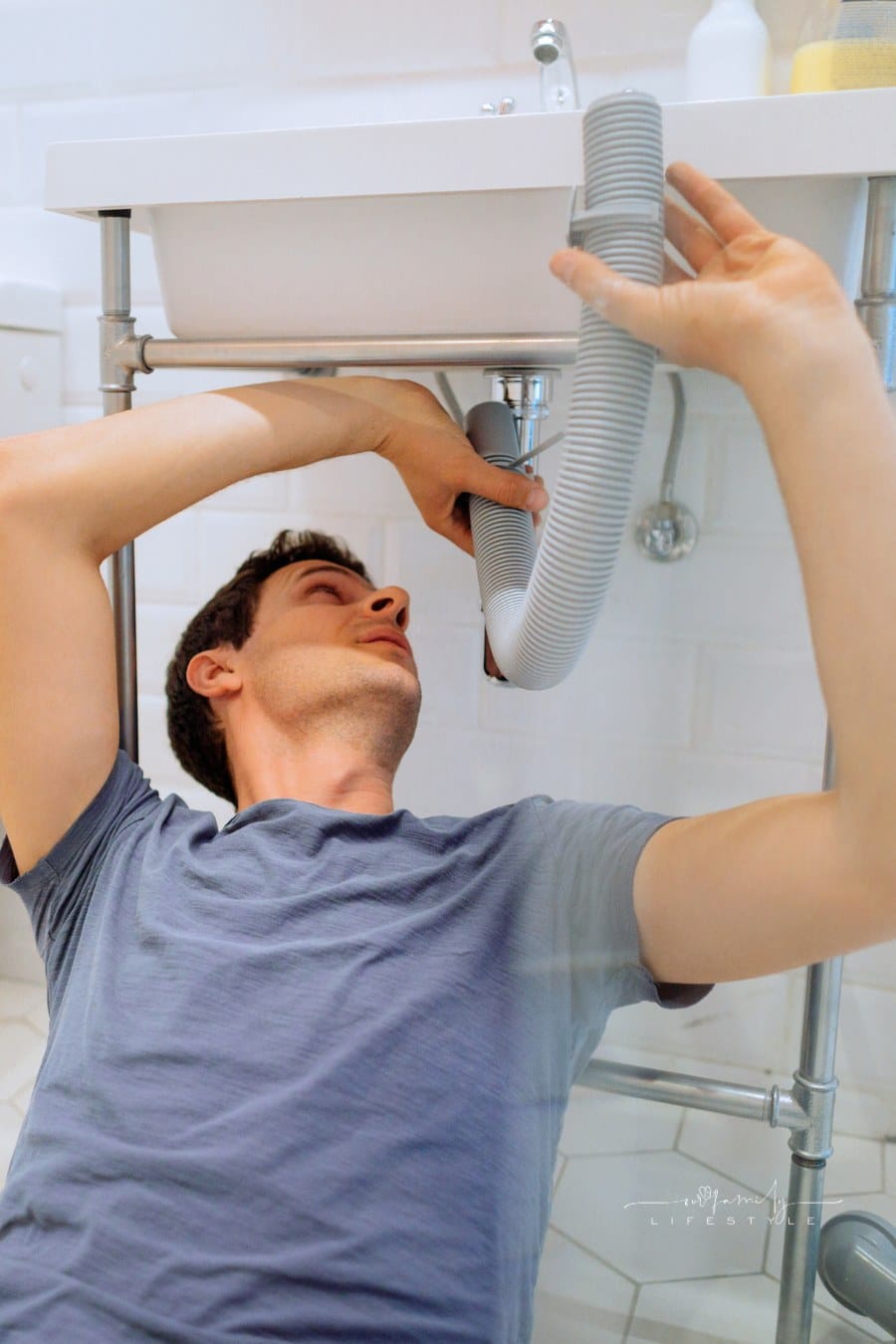 Young man repairing drain in his bathroom