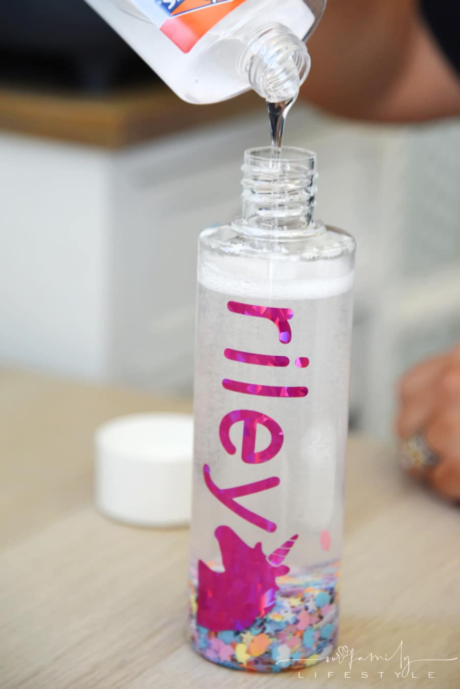 pouring clear glue into sensory calm bottle
