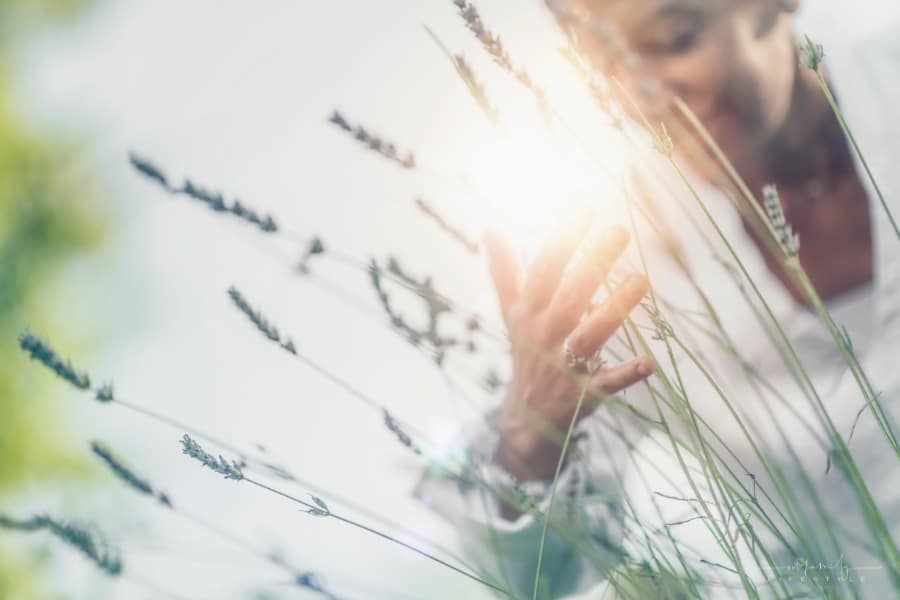 smiling woman breathing in flowers in the sunshine with a grateful heart