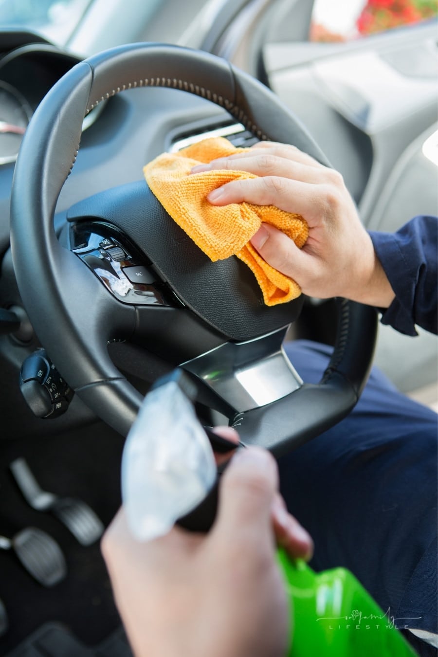 man cleaning steering wheel of car with rag