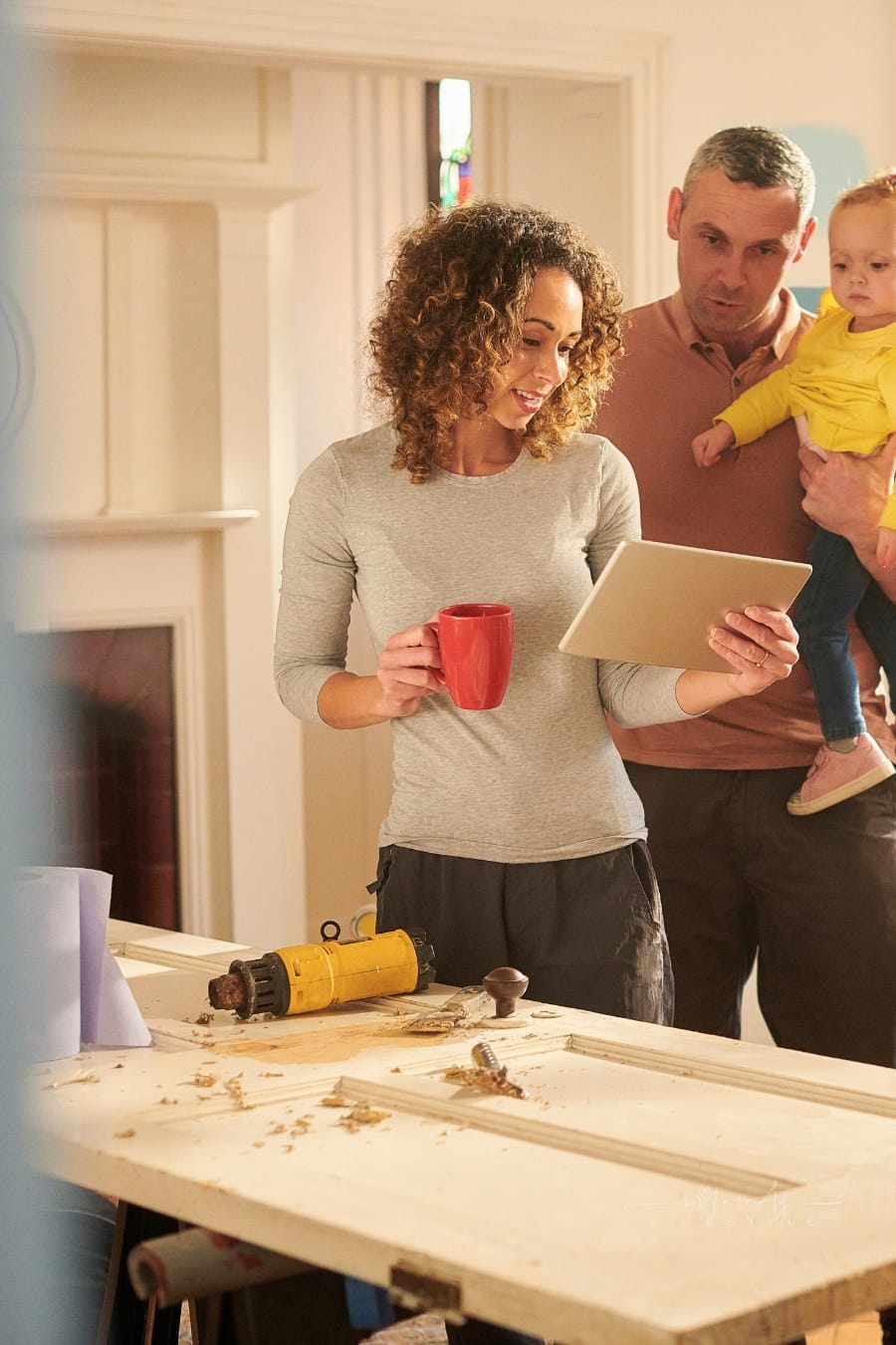 young couple with toddler looking at home renovation plans on a tablet