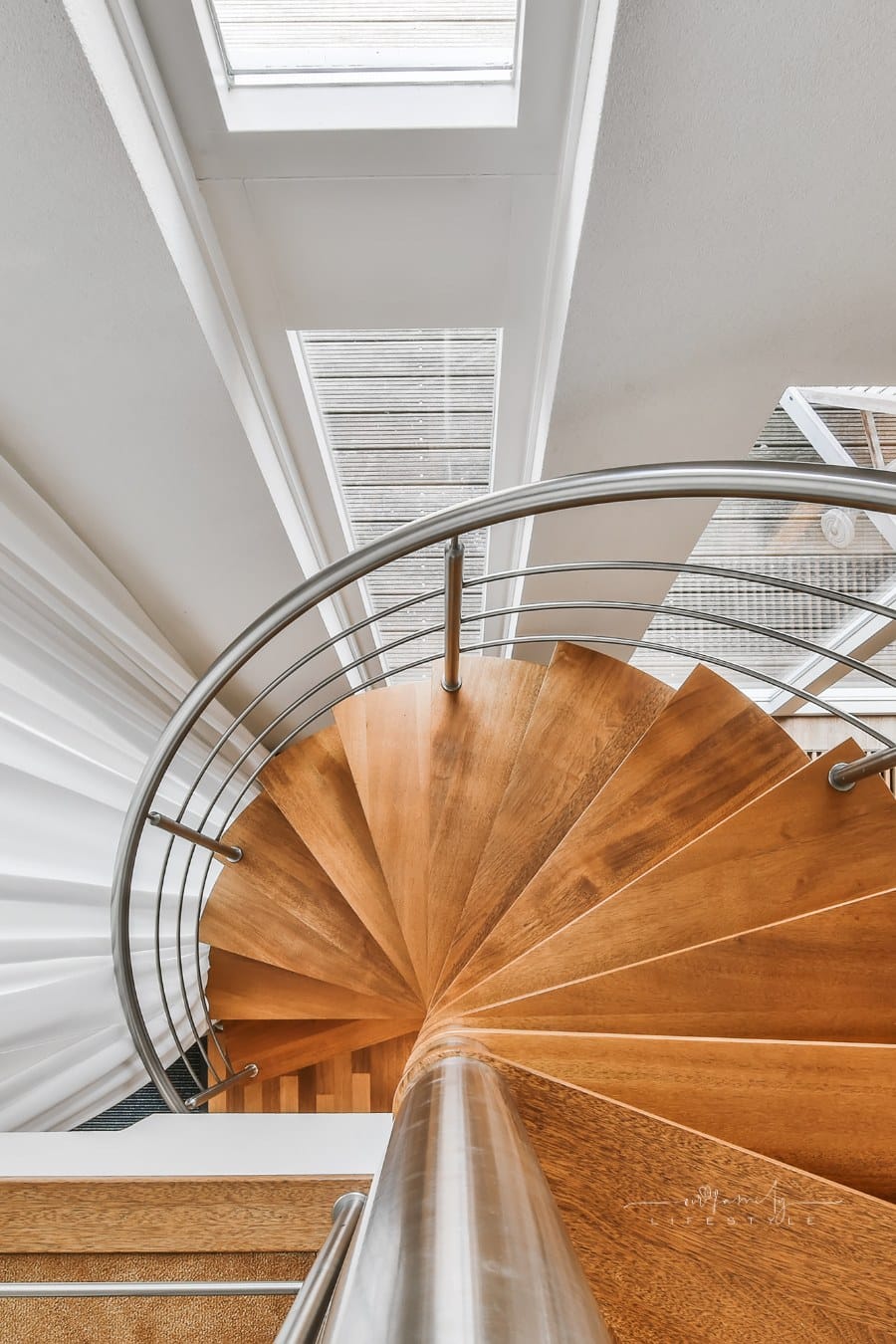 wooden spiral staircase with metal banisters and railing