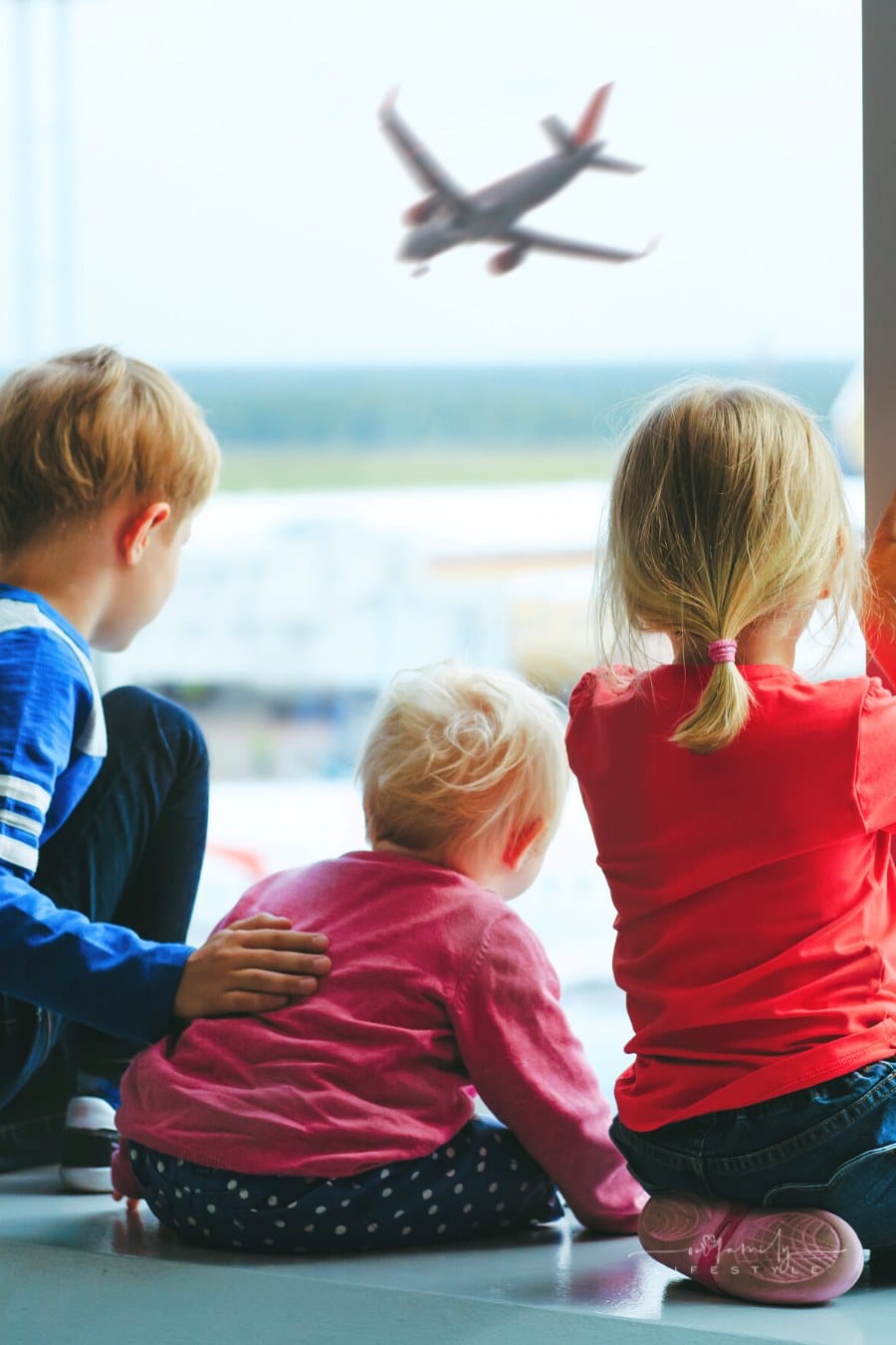 kids watching for plane in airport