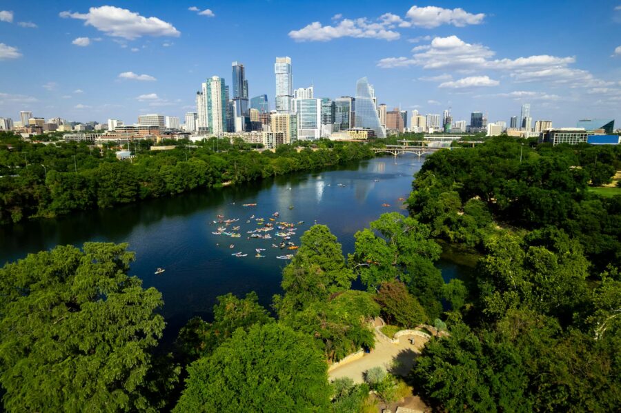 Scenic aerial view of downtown Austin, Texas, featuring the river and lush greenery.