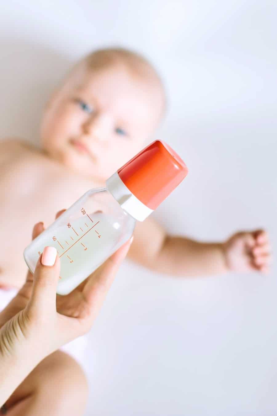 Mother holding and feeding baby from bottle