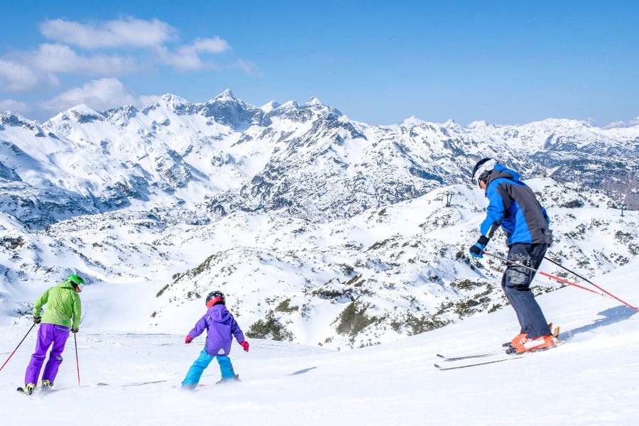 family skiing on a snowy slope
