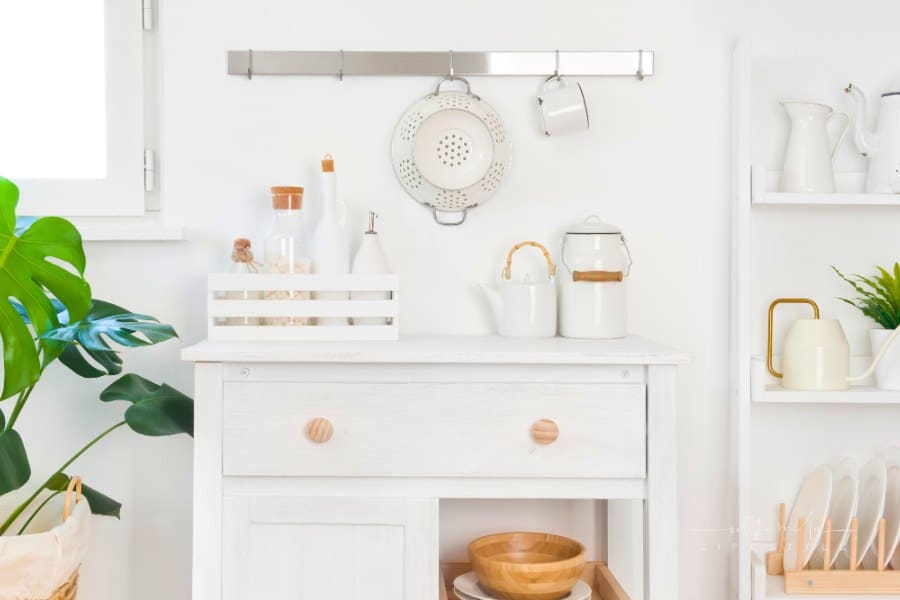 Refined white kitchen cabinet with various utensils. Storage and organizing concept