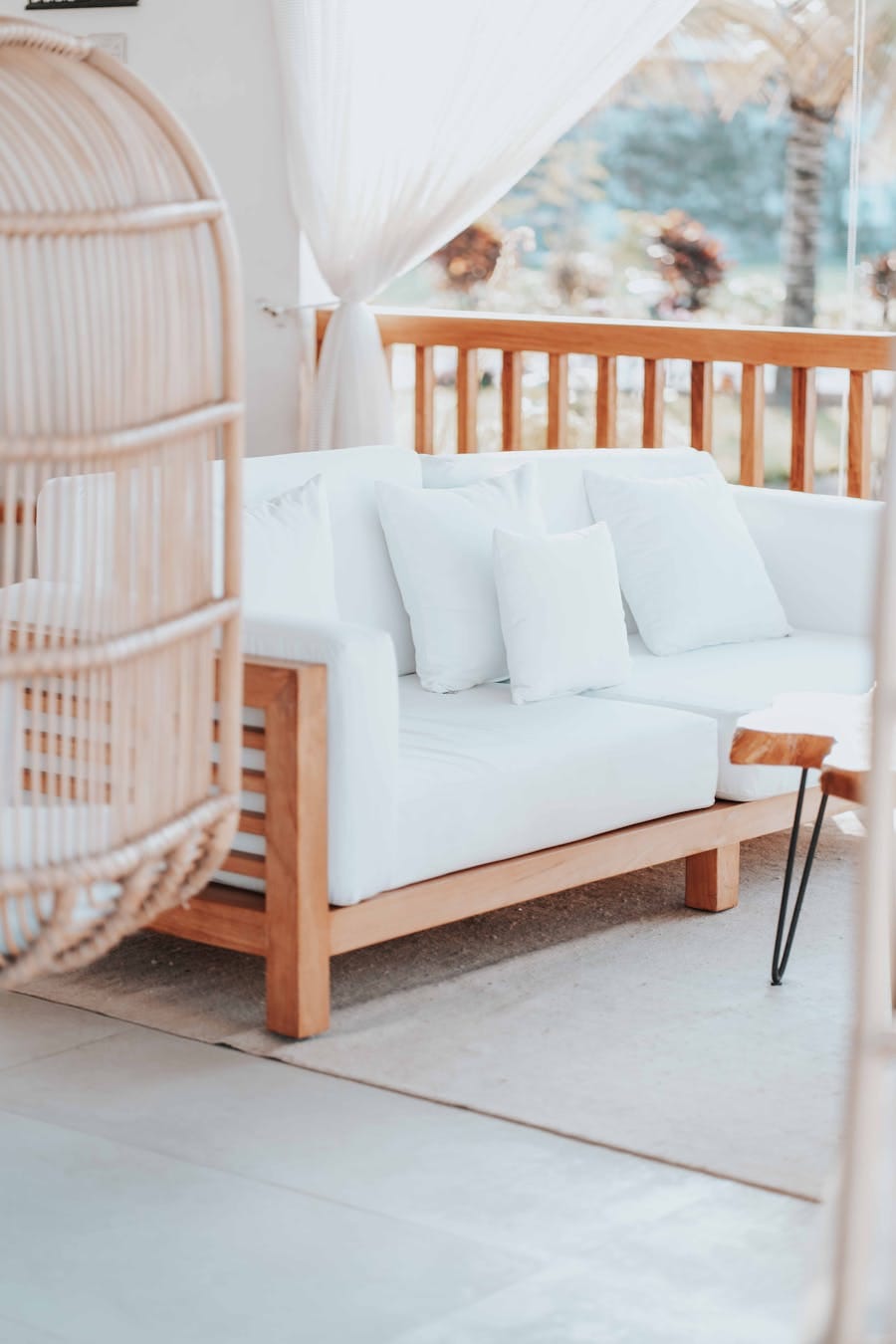 Stylish outdoor patio showcasing a modern wooden sofa set with cushions and swing chair.