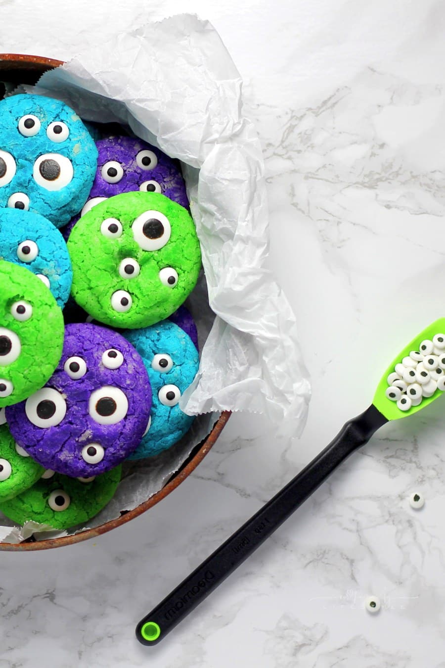 green, purple, and turquoise sugar cookies with edible eyes