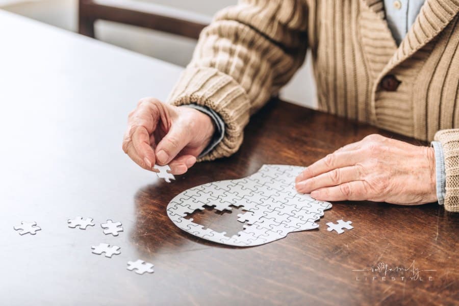 cropped view of senior man playing with puzzles