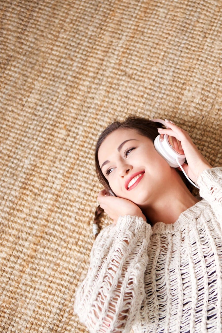 Woman Lying down smiling while listening to Headphones