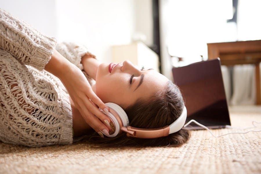 Woman Lying down smiling while listening to Headphones