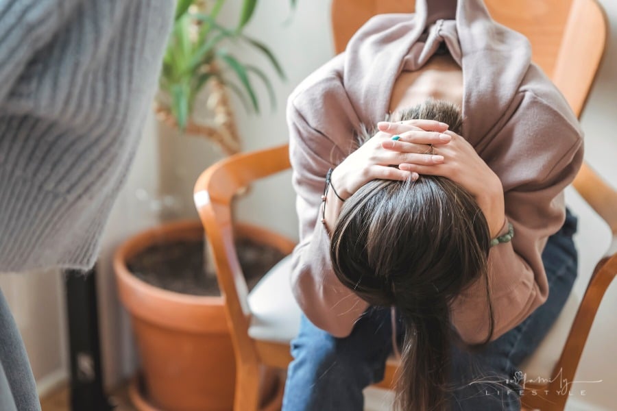 sad woman holding her head between her knees