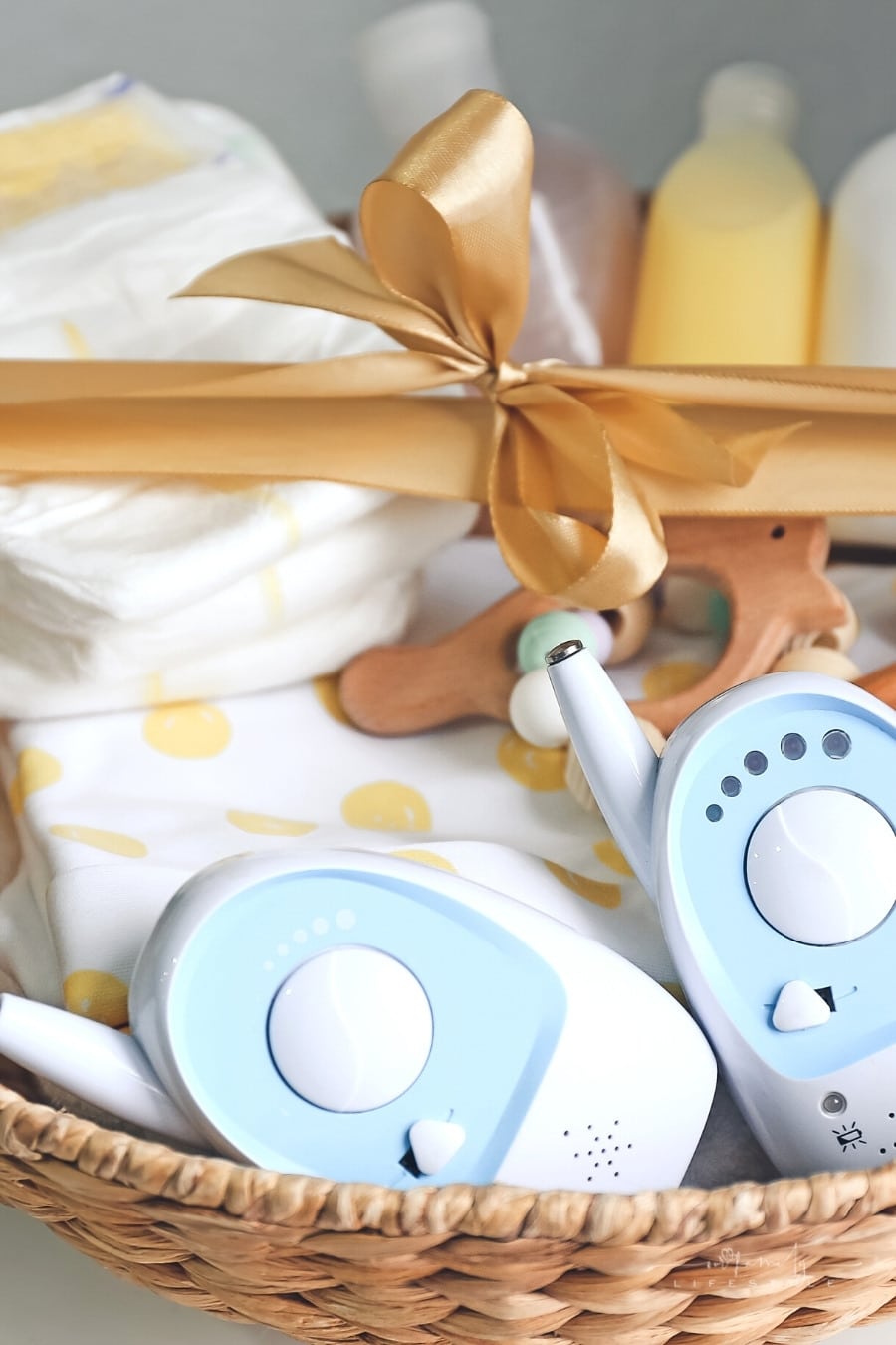 wicker basket with gold bow filled with gifts for baby
