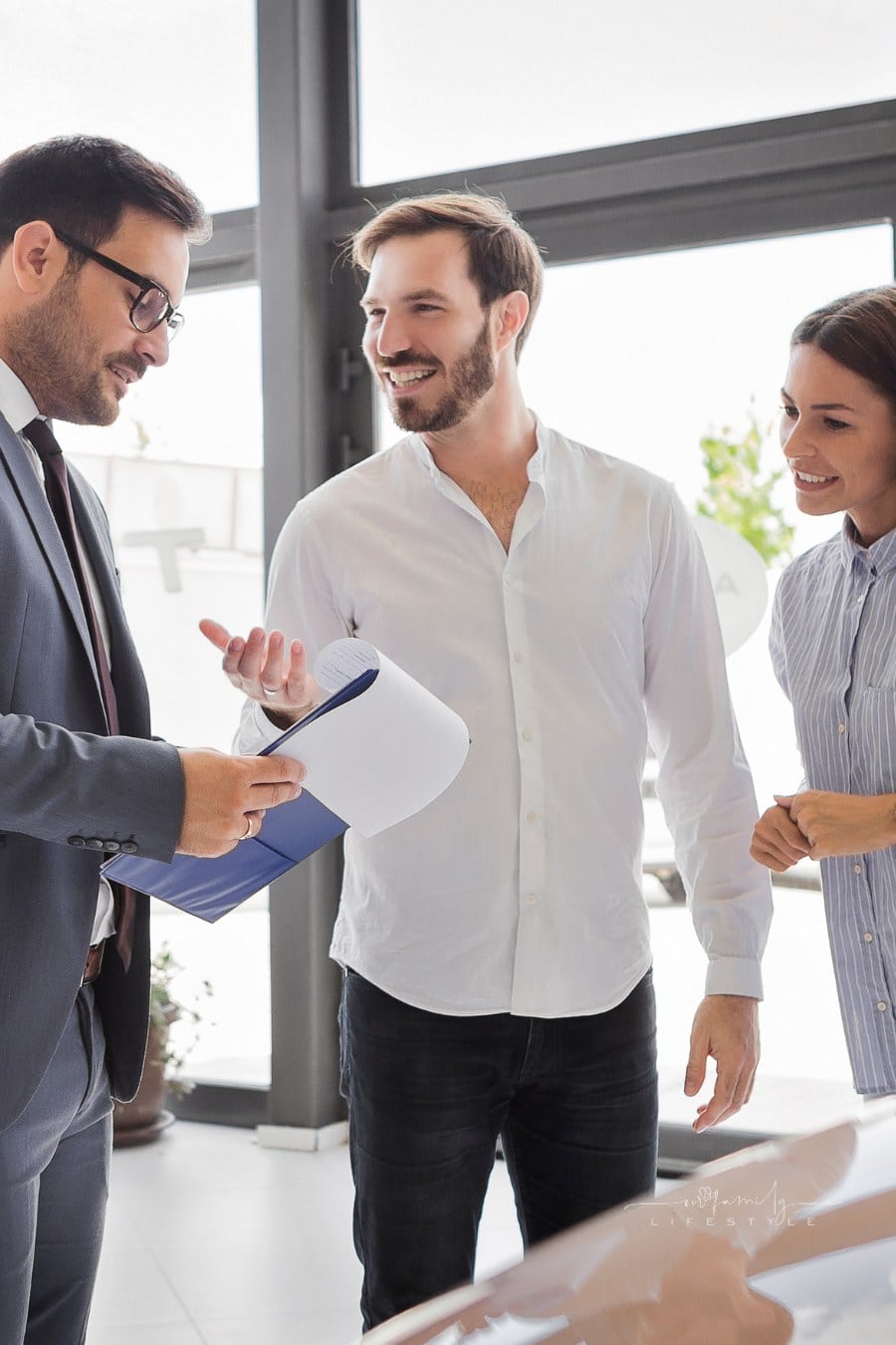 Young couple buying a car at auto dealership