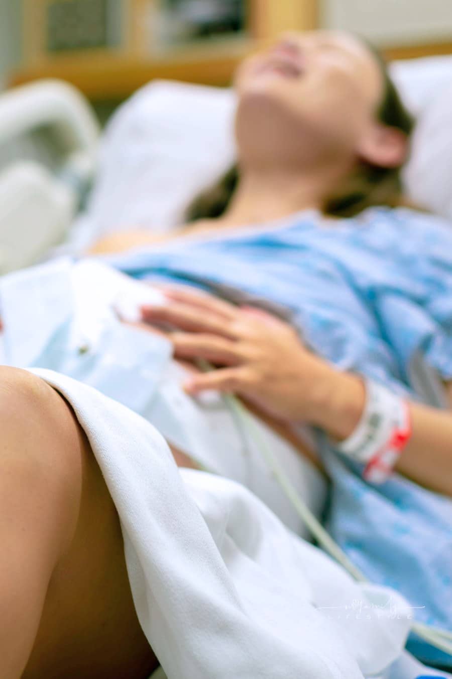 A woman in labor, with painful contractions, lying in the hospital bed. Childbirth and baby delivery.