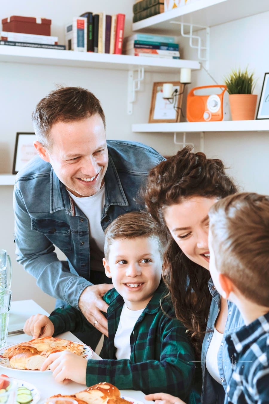 Mom and Dad enjoying pizza dinner with two young sons at table