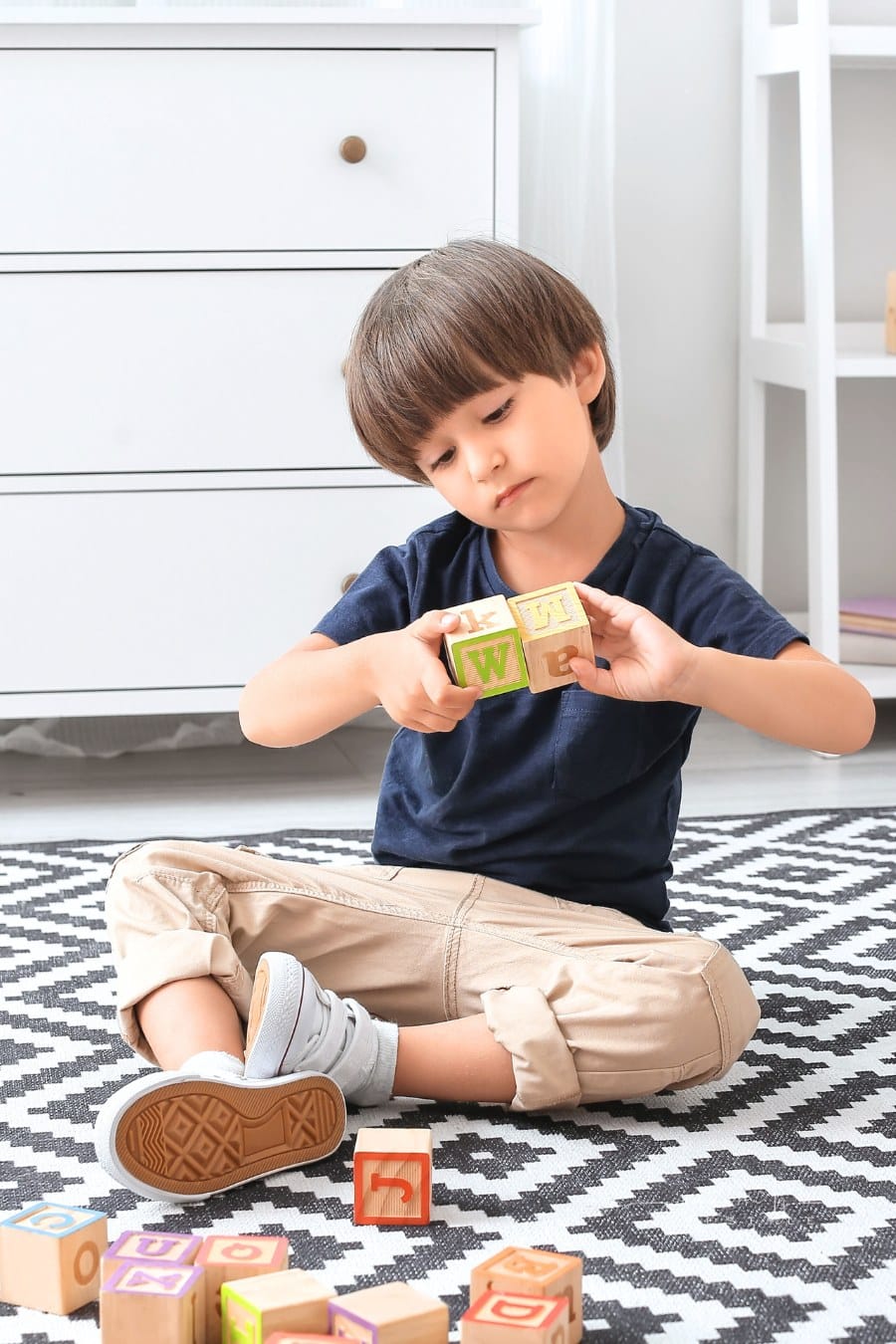 Little Boy with Disorder Playing Alone with Wooden Blocks