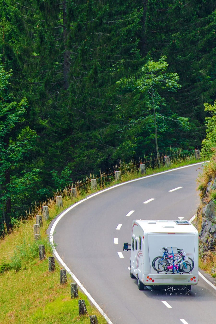 Camper Journey. Small Class B Camper Van with Whole Family Bikes on the Forest Road. Camper Travel.