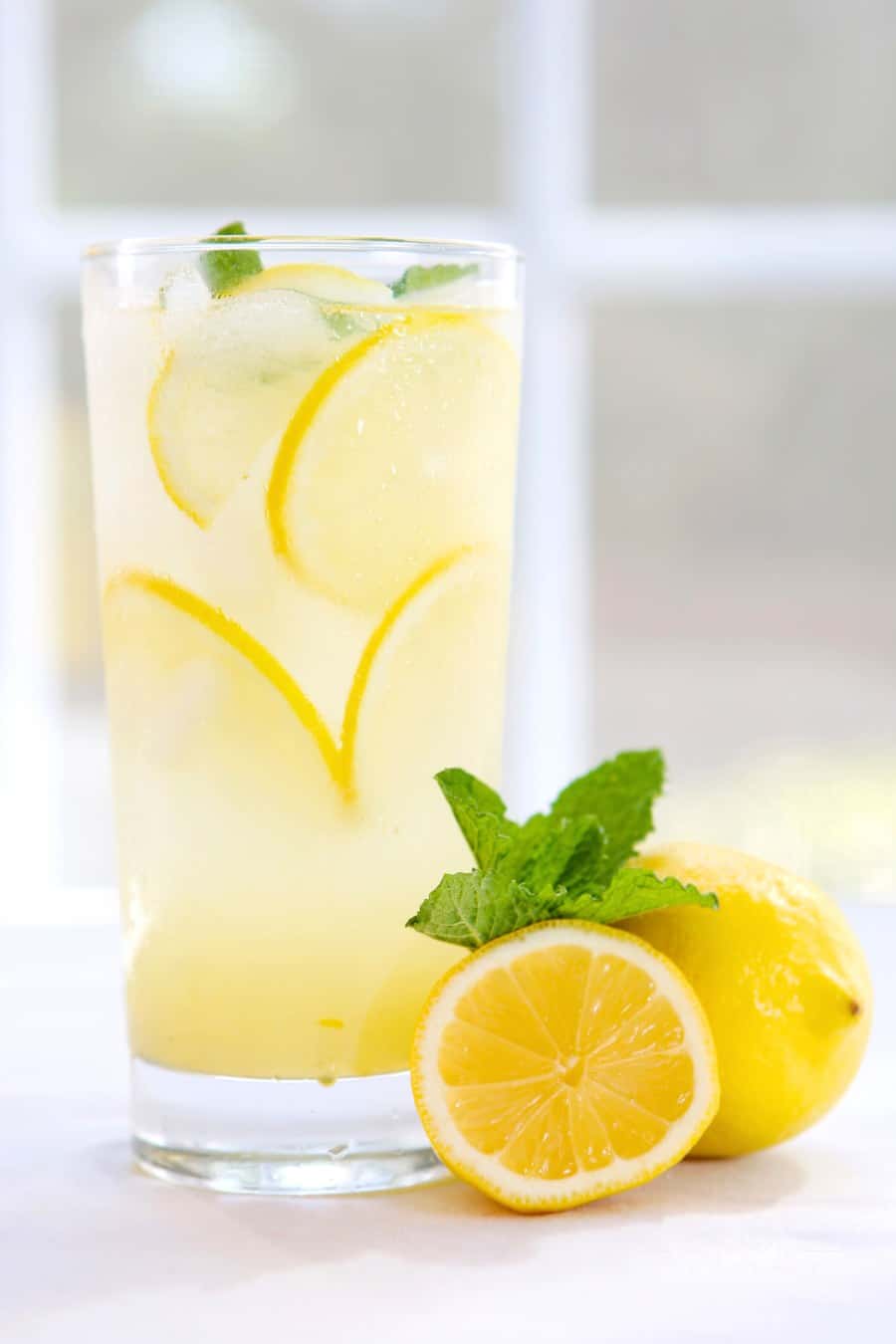 homemade lemonade in a glass with lemon slices on a table