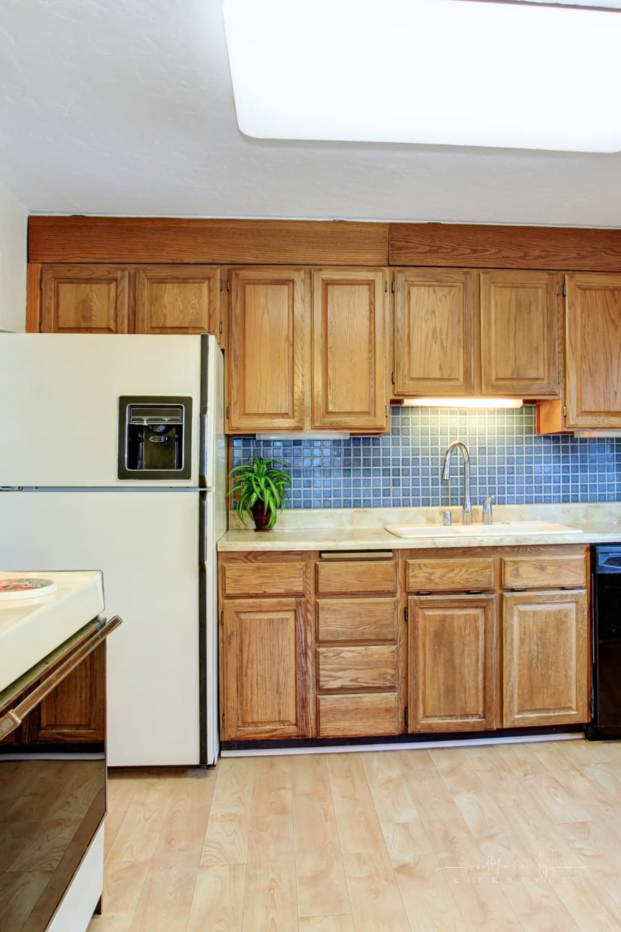 outdated kitchen with hardwood floor, a door, and old appliances