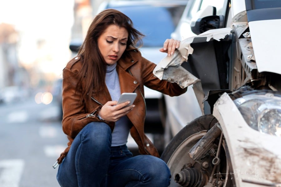 distraught woman on phone after car accident