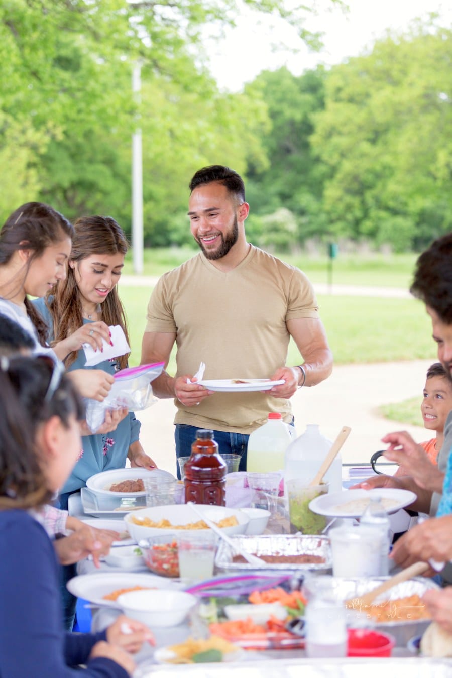 Large family enjoys picnic at the park on sunny day