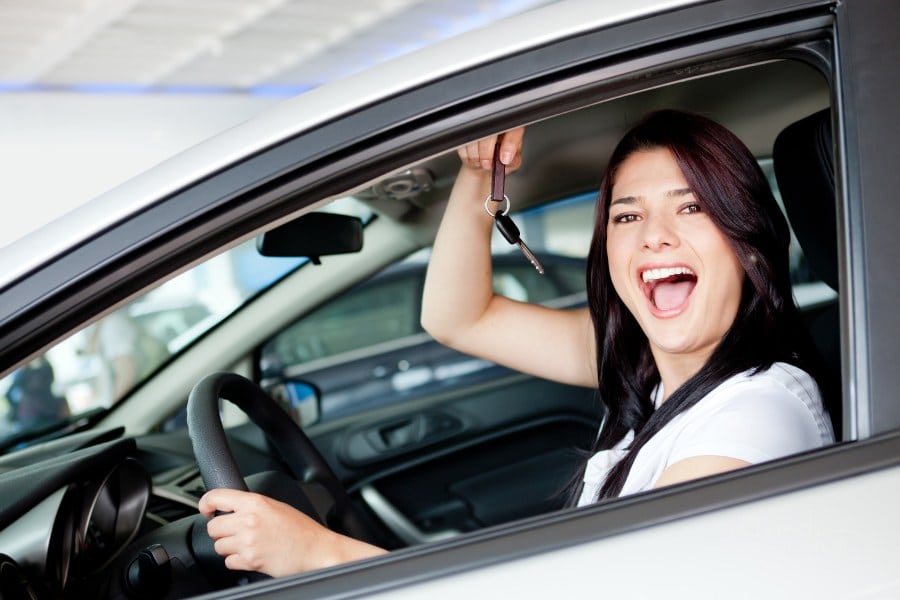 Excited woman buying a car and holding keys