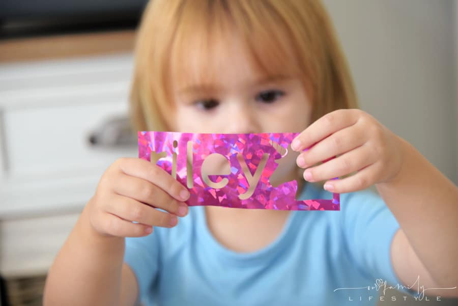 toddler holding vinyl cutout in her hands