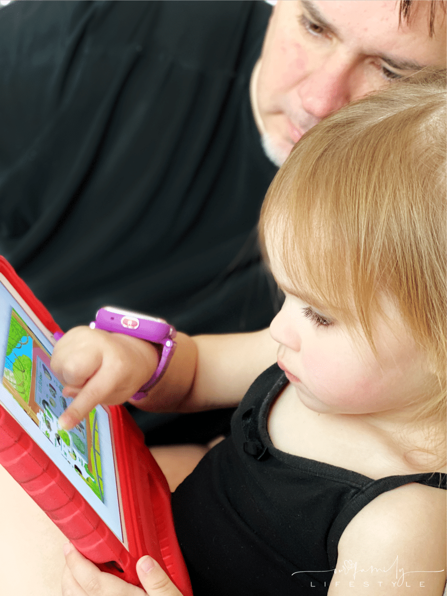 toddler playing ABCmouse games on iPad with grandfather