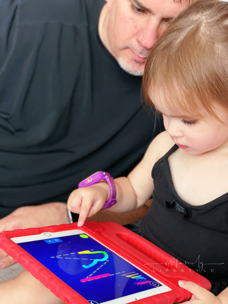 toddler tracing letters on ABCmouse on iPad with grandpa