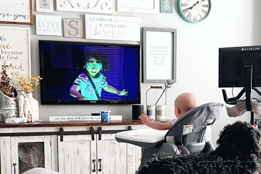 toddler watching Encanto while sitting in high chair