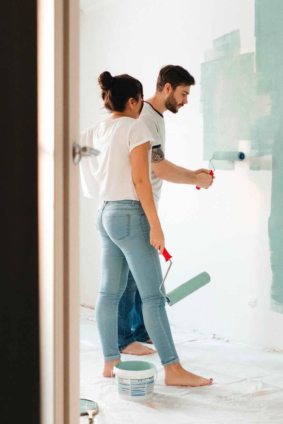 couple painting interior wall in house
