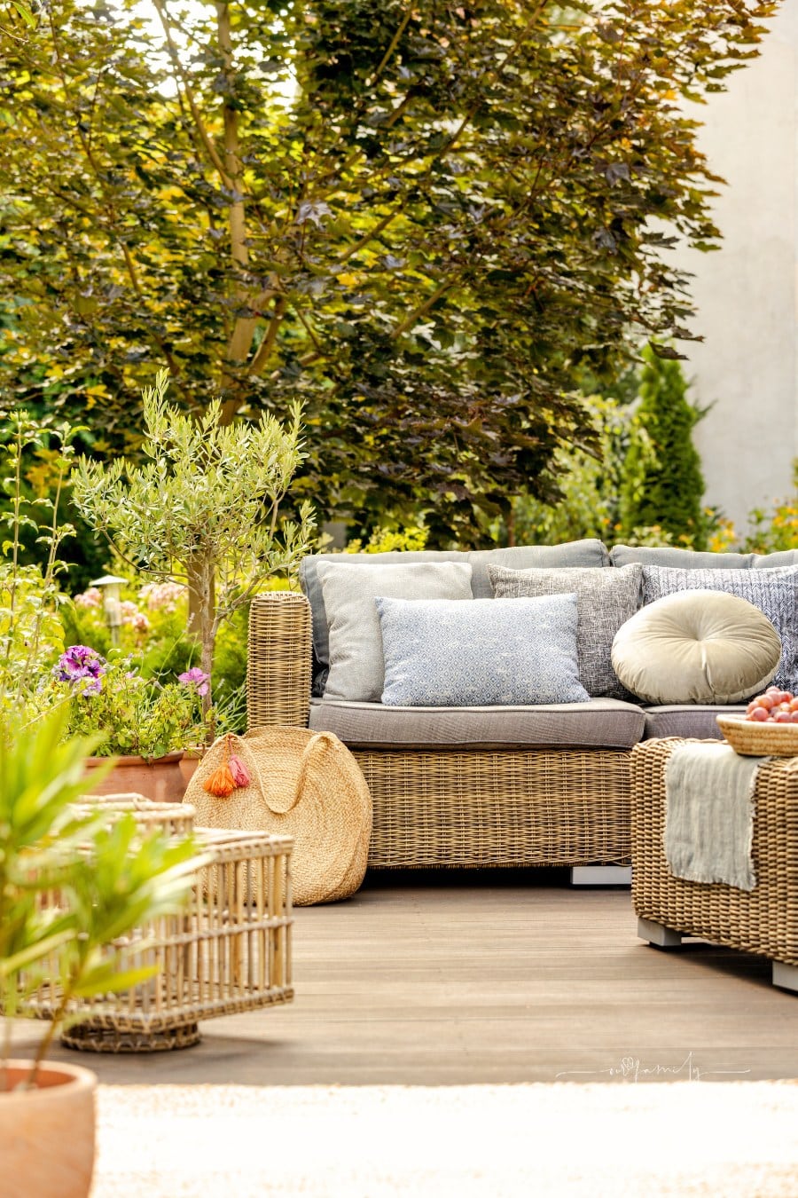 View of cozy green backyard with wicker sofa and decorations