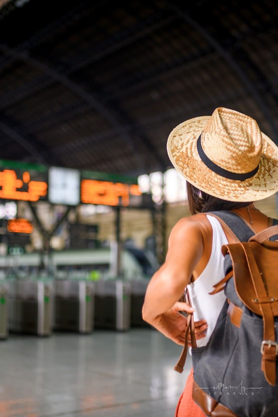 female traveler with backpack awaiting train at the station